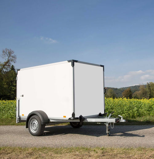 Small enclosed trailer sitting on a gravel road